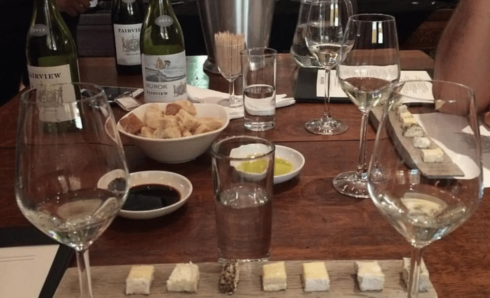 A tasting table set with Fairview bottles, cheese, bread and olive oil