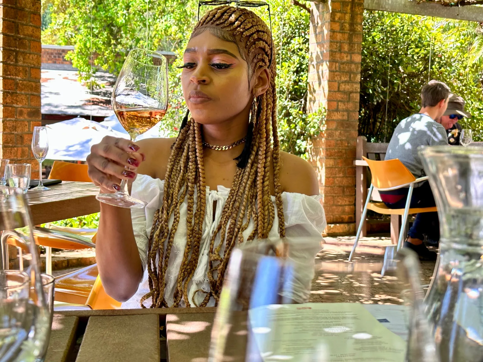 A guest tasting rosé on a shaded estate terrace
